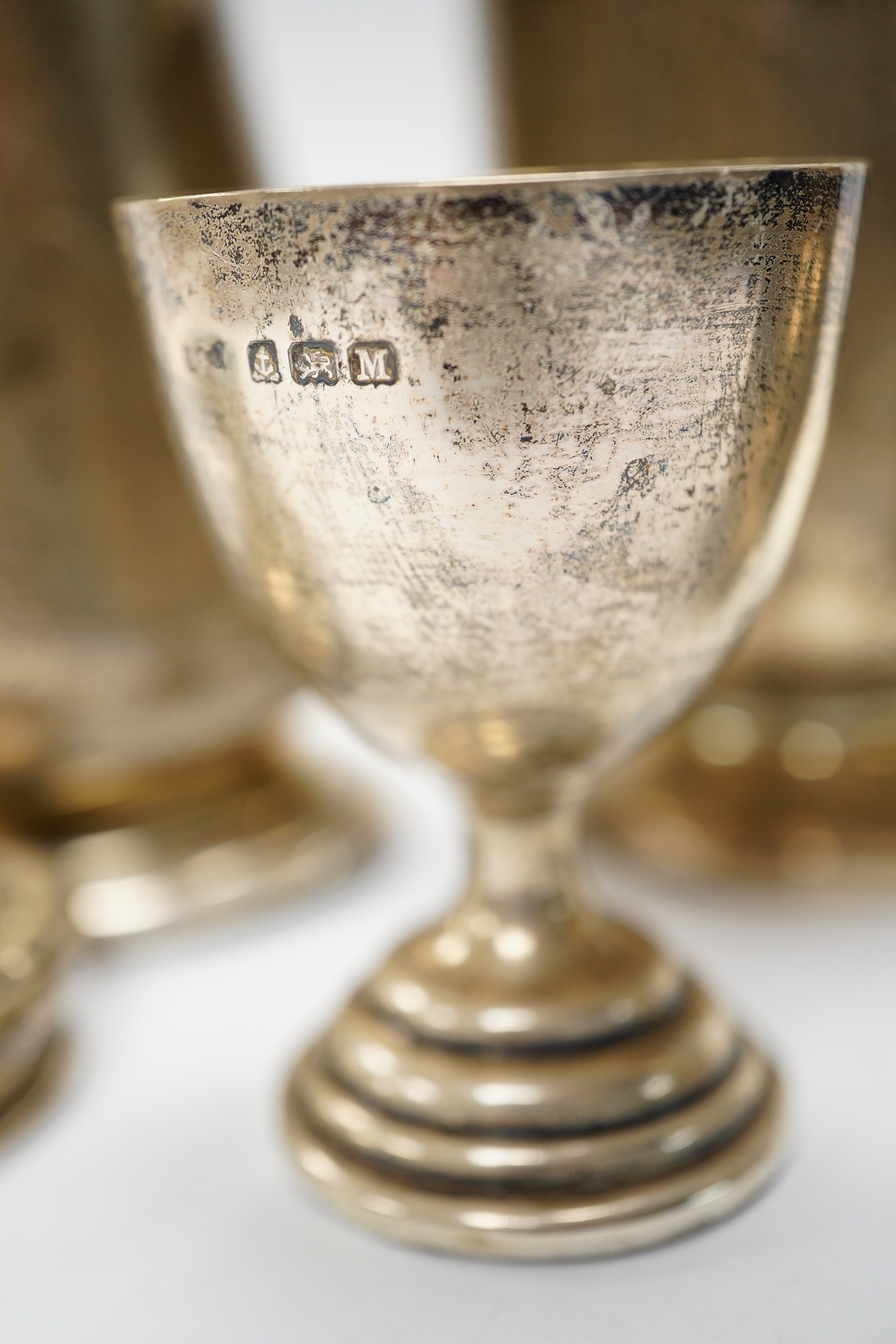 Six items of small silver:- two christening mugs, a cream jug, a salt, an egg cup and a box lid. Condition - poor to fair